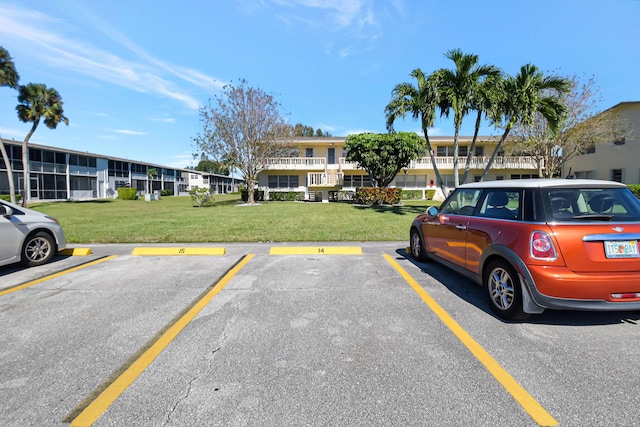 view of vehicle parking with a lawn