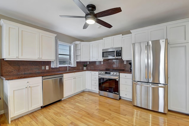 kitchen with white cabinetry, light hardwood / wood-style flooring, ceiling fan, and stainless steel appliances