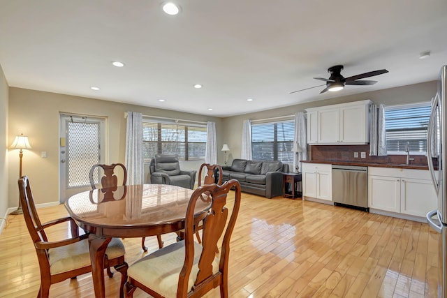 dining space with light hardwood / wood-style flooring, ceiling fan, and sink