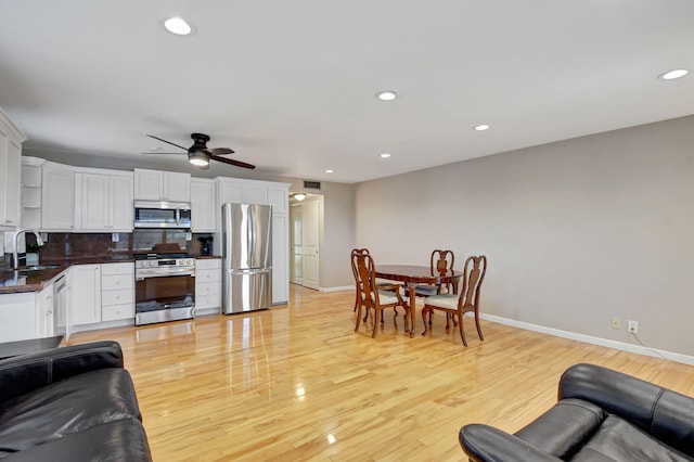 kitchen featuring white cabinetry, sink, tasteful backsplash, appliances with stainless steel finishes, and light wood-type flooring