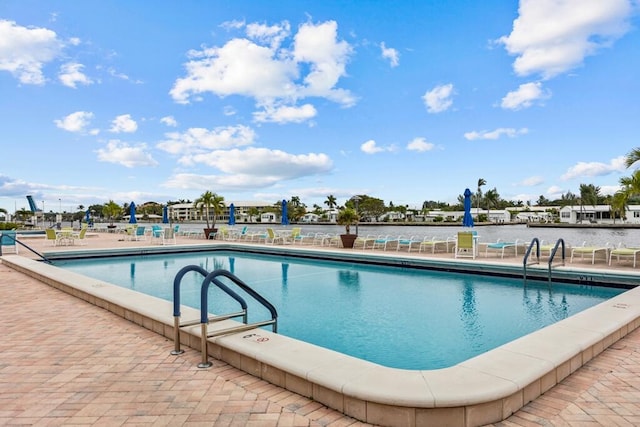 view of swimming pool with a patio area and a water view