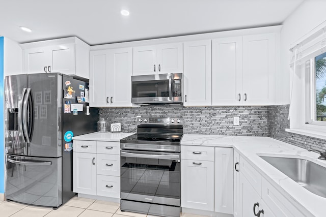 kitchen with white cabinets, light tile patterned floors, and appliances with stainless steel finishes