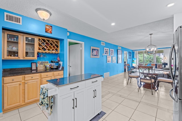 kitchen with decorative light fixtures, light tile patterned floors, and a textured ceiling