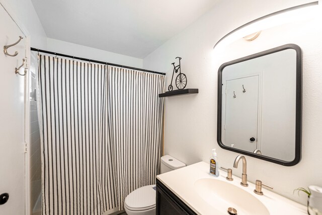 bathroom featuring vanity, toilet, and curtained shower