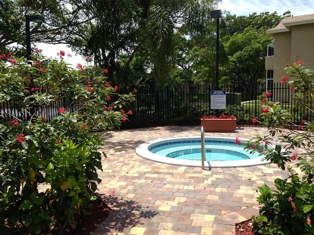 view of swimming pool with a hot tub