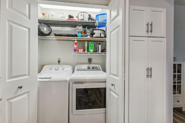 clothes washing area featuring laundry area, washing machine and dryer, and wood finished floors