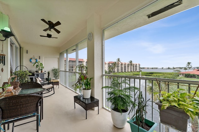 balcony with a water view and ceiling fan