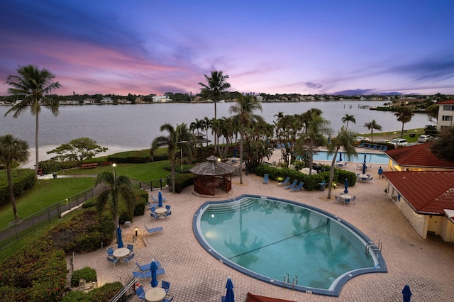 pool featuring a water view, a patio area, fence, and a gazebo