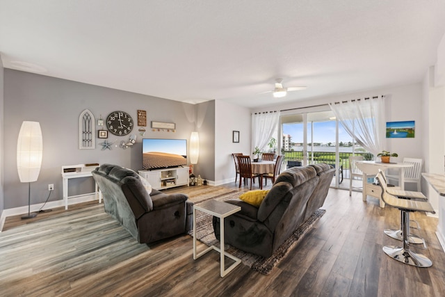 living area with ceiling fan, baseboards, and wood finished floors