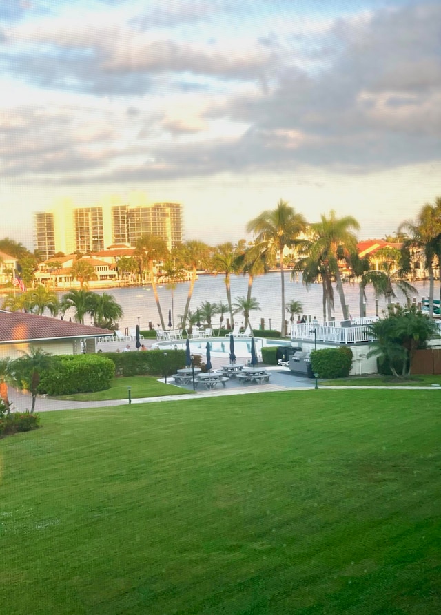 view of home's community featuring a lawn and a water view