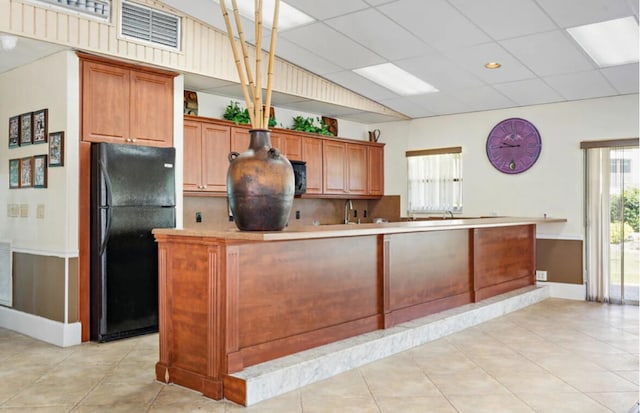 kitchen featuring black appliances, a paneled ceiling, light tile patterned floors, and decorative light fixtures