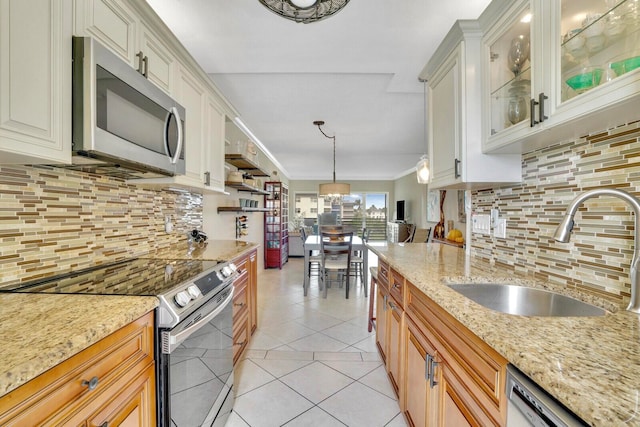 kitchen featuring sink, stainless steel appliances, light stone counters, backsplash, and decorative light fixtures