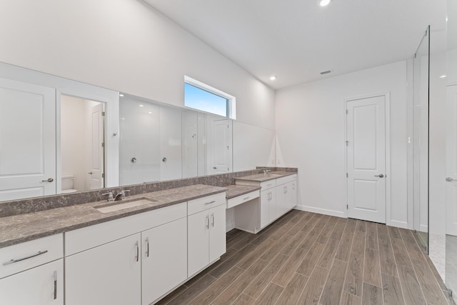 bathroom featuring vanity, hardwood / wood-style flooring, a shower, and toilet