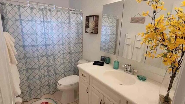 bathroom featuring tile patterned flooring, vanity, and toilet