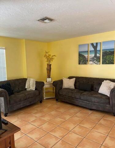 tiled living room with a healthy amount of sunlight and a textured ceiling