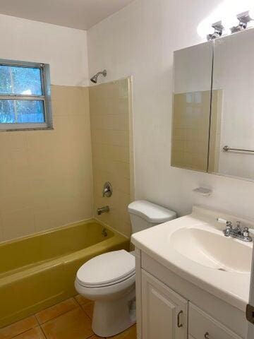 full bathroom with tile patterned floors, tiled shower / bath combo, toilet, and vanity