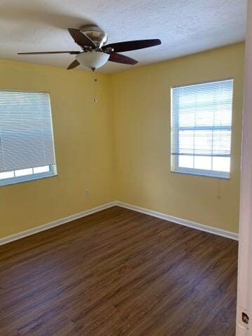 unfurnished room with a textured ceiling, ceiling fan, and dark hardwood / wood-style floors