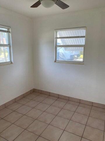 spare room featuring light tile patterned floors and ceiling fan