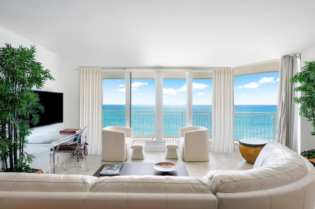 living room featuring a water view, a wall of windows, and light hardwood / wood-style floors