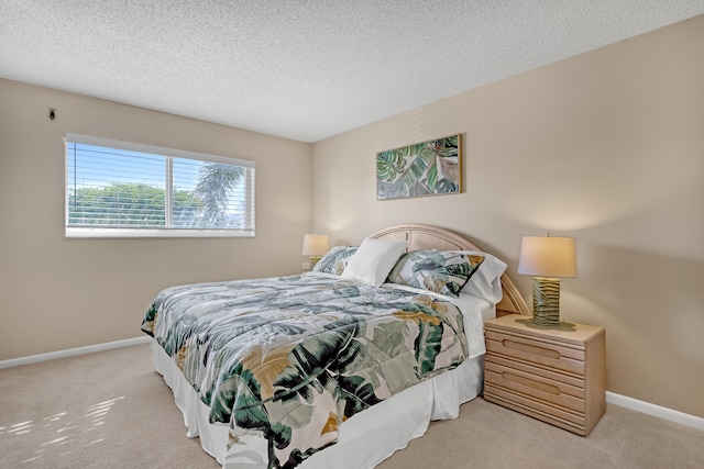 bedroom with light carpet and a textured ceiling