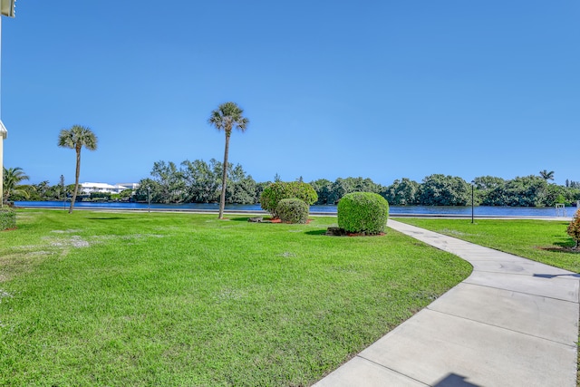 view of property's community featuring a yard and a water view