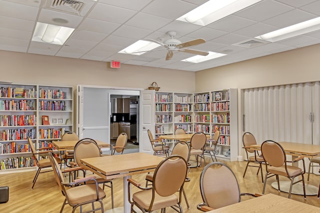 interior space with light wood-type flooring, ceiling fan, and a paneled ceiling