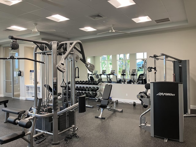 gym with ceiling fan and a drop ceiling