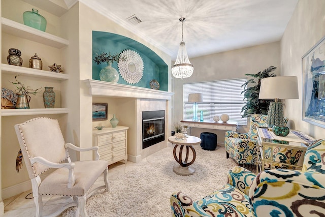 living room featuring a notable chandelier, light tile patterned floors, crown molding, and a tile fireplace