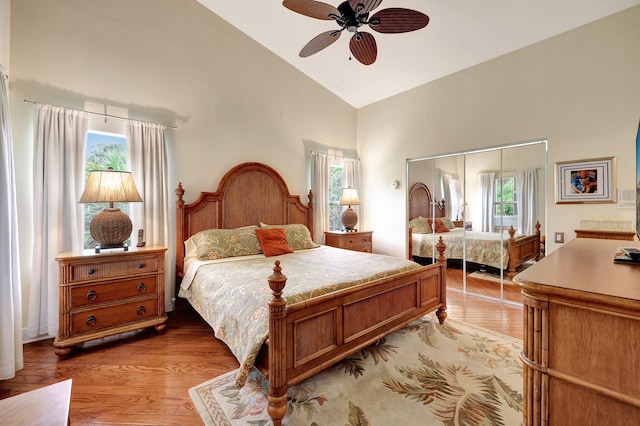 bedroom with multiple windows, ceiling fan, a closet, and light wood-type flooring