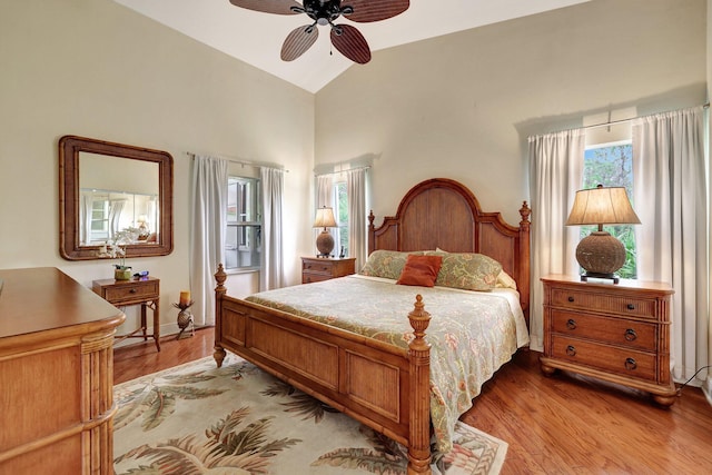 bedroom with light hardwood / wood-style floors, vaulted ceiling, and ceiling fan