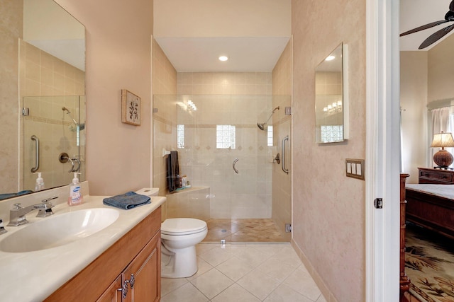 bathroom with vanity, tile patterned flooring, ceiling fan, toilet, and walk in shower