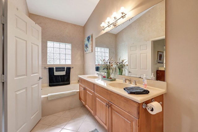 bathroom with vanity, lofted ceiling, tile patterned flooring, a washtub, and tile walls