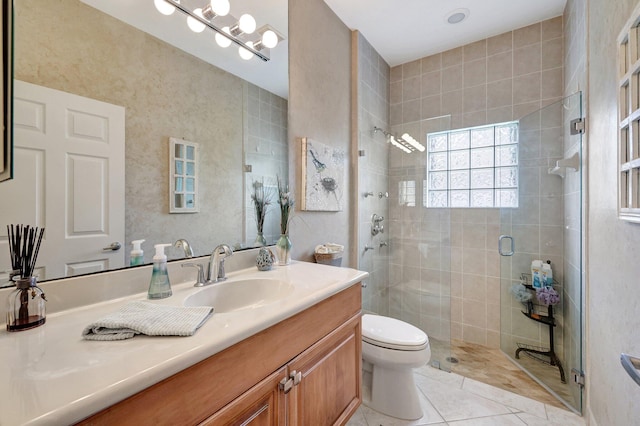 bathroom featuring tile patterned flooring, vanity, toilet, and an enclosed shower