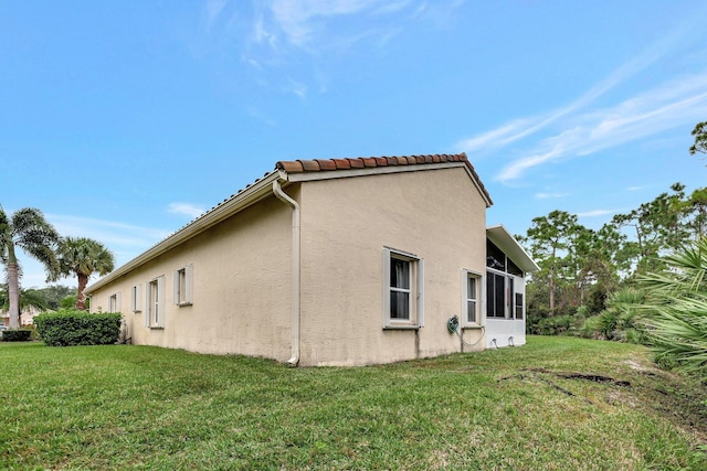 view of side of home with a lawn