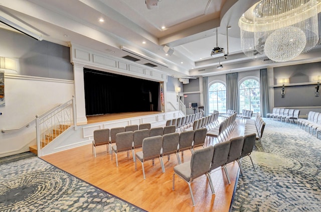 home theater room with hardwood / wood-style flooring and a raised ceiling