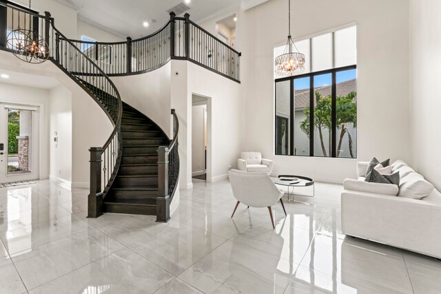 living room with a chandelier, a high ceiling, and ornamental molding