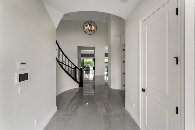 entryway featuring a towering ceiling and an inviting chandelier