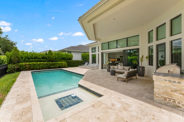 view of pool with an outdoor living space, area for grilling, and a patio