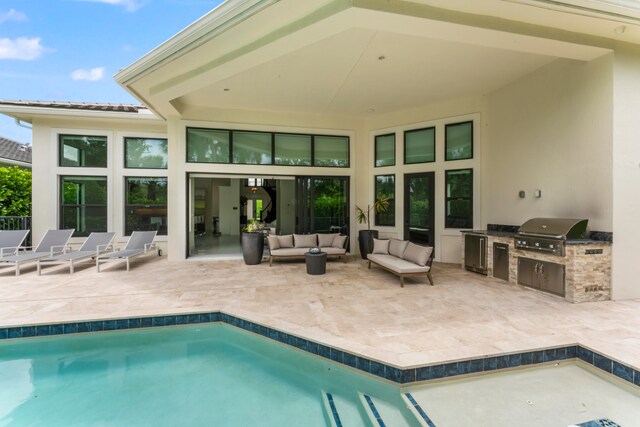 rear view of property with outdoor lounge area, an outdoor kitchen, and a patio