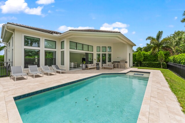 back of house featuring an outdoor living space, a patio, and a fenced in pool