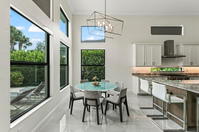 dining area with ornamental molding, a wealth of natural light, and an inviting chandelier