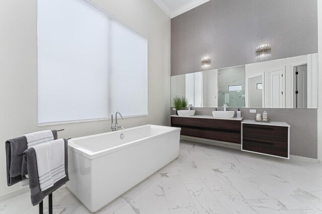 bathroom featuring vanity, a towering ceiling, crown molding, and a tub