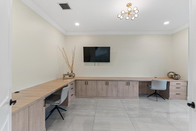 home office with built in desk and ornamental molding