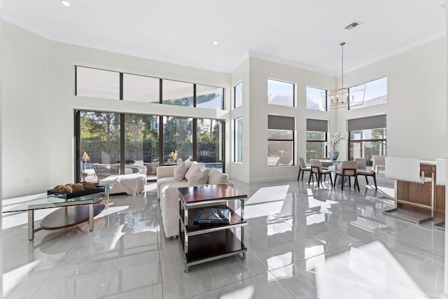 living room featuring crown molding, plenty of natural light, a chandelier, and a high ceiling