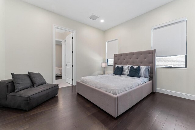 bedroom with dark hardwood / wood-style flooring and connected bathroom