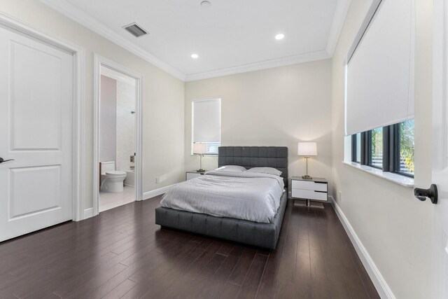 bedroom featuring ensuite bathroom, dark hardwood / wood-style flooring, and crown molding