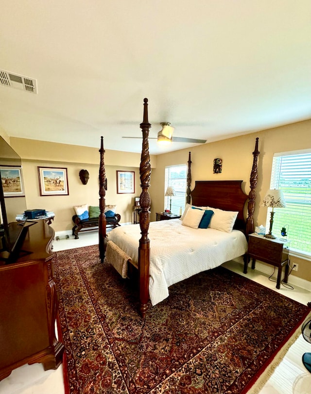 carpeted bedroom featuring multiple windows and ceiling fan