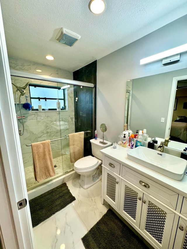 bathroom with vanity, toilet, an enclosed shower, and a textured ceiling