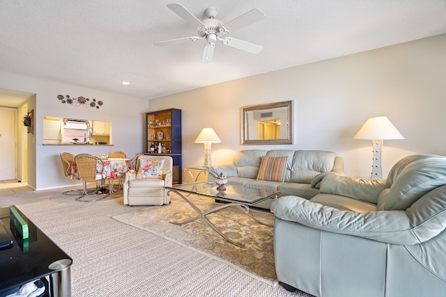 living room featuring carpet, a textured ceiling, and ceiling fan