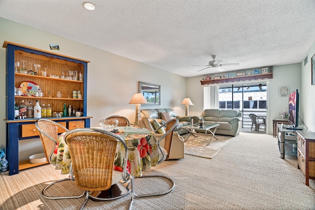 living room featuring carpet, bar area, a textured ceiling, and ceiling fan